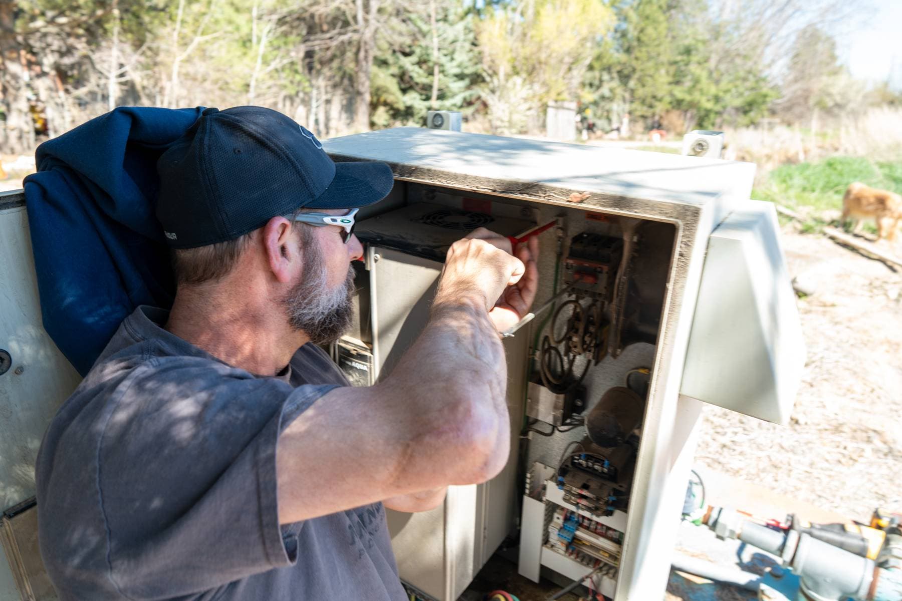 Technician working inside a control panel.
